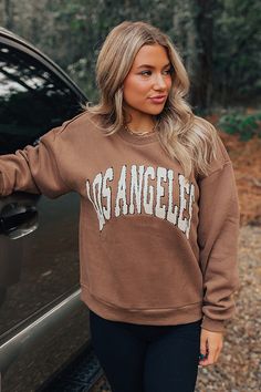 - Be proud of your city in this trendy sweatshirt! - Unlined warm material with cream colored sherpa 'LOS ANGELES' lettering - A crew cut neckline - Long, loose sleeves with fitted ribbed cuffs - A slouched silhouette that ends in a straight hemline with a ribbed texture Fall Streetwear Sweater With Letter Embroidery, Brown Relaxed Fit Sweatshirt With Letter Print, Fall Streetwear Sweatshirt With Letter Embroidery, Relaxed Fit Brown Sweatshirt With Letter Print, Fall Letter Embroidery Sweatshirt For Streetwear, Oversized Fall Sweatshirt With Letter Embroidery, Oversized Sweatshirt With Letter Embroidery For Fall, Brown Winter Sweatshirt With Letter Print, Brown Letter Print Sweatshirt For College