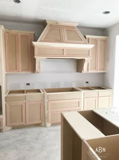 an empty kitchen with unfinished cabinets in it