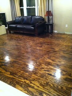 a living room with wood floors and leather couches