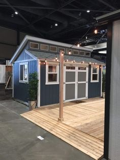 a blue and white shed with lights on it