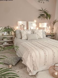 a white bed sitting in a bedroom next to a plant