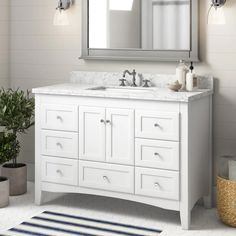 a white bathroom vanity with two mirrors above it