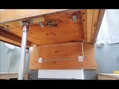 an overhead view of a wooden ceiling with metal bars and brackets on the bottom floor