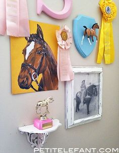 the wall is decorated with pictures, ribbons and horse related items in pastel colors