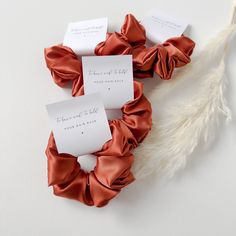 three scrunffle hair ties on top of each other with name tags attached to them