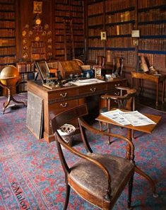 an old fashioned desk and chair in a room full of books