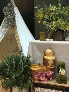 an arrangement of plants and stuffed animals on display in front of a teepee tent