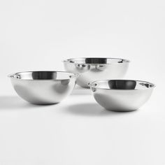 three silver bowls sitting next to each other