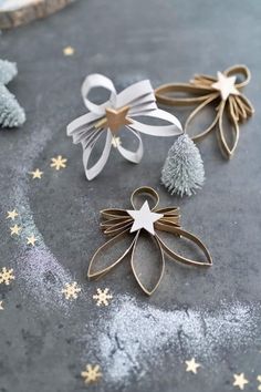 three christmas decorations on a table with snowflakes and stars in the foreground