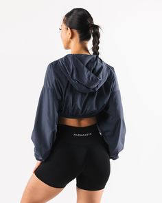 HIGHLIGHTS. Woven fabric Long sleeve Alphalete wolf logo FIT SUGGESTION. This item runs true to Alphalete's standard size... Jessica is 5’3”/160cm, wearing a size XS with a 30”/77.5cm bust. MATERIALS AND WASHING DIRECTIONS. 100% Polyester. We recommend washing inside-out on a cold setting. Hang to dry DESCRIPTION With a silky smooth woven fabric, this jacket is perfect for wearing to and from the gym or during a cold outdoor workout for some added warmth. The wide sleeves and gathered hem make f Nylon Athleisure Hooded Jacket With Pockets, Hooded Moisture-wicking Track Jacket For Athleisure, Athleisure Moisture-wicking Hooded Jacket, Outdoor Athleisure Windbreaker With Double-lined Hood, Wolf Logo, Sporty Moisture-wicking Nylon Hooded Jacket, Outdoor Workout, Outdoor Workouts, Wide Sleeves