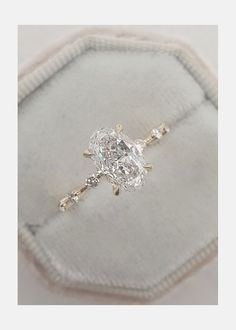 a diamond ring sitting on top of a cushion