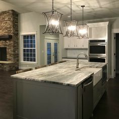 a large kitchen with an island in the middle and two ovens on each side