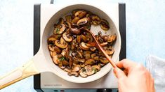 someone is cooking mushrooms in a pan on the stove