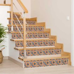 the stairs are decorated with colorful tiles and wooden handrails, along with a potted plant