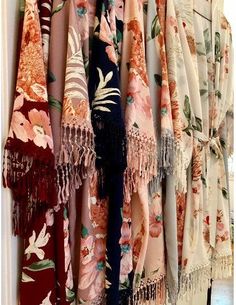 many different types of scarves hanging on a wall