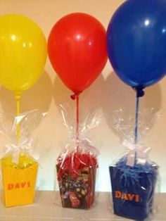 three balloons and some candy in bags on a table with the words day written on them