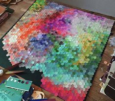 there is a large multicolored area rug on the floor next to some craft supplies