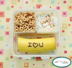 a plastic container filled with cereal, pretzels and a banana that says i love you