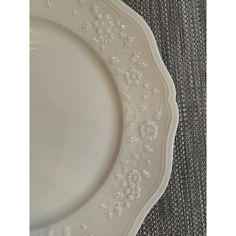 a white plate with flowers on it sitting on a gray tableclothed flooring