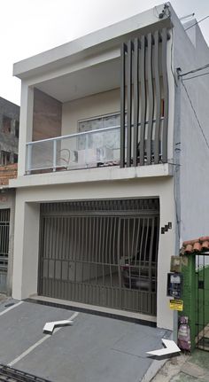 an empty parking lot in front of a two story building with a balcony on the second floor