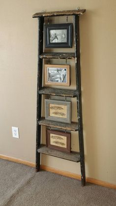 an old ladder leaning against the wall with pictures on it and two framed photos below