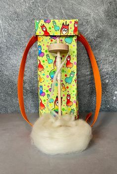 an orange and white object on top of a gray table next to a bag with handles