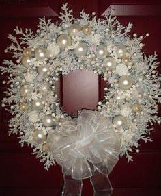 a christmas wreath with white and gold ornaments