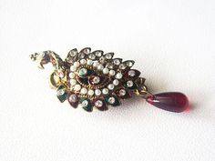 A beautiful peacock shape jewelry designed to be attached on dress or saree, often to hold them close. This lovely peacock shaped metal brooch has a glamorous golden look and is set with elegant white rhinestones and green and red elements. This one of a kind brooch ornament will add instant glamour and sophistication to any outfit. Measures: 2.5 by 1 inches approx The Pin is very good quality so perfect gathering lots of material. Lots of other designs available in my shop! Will be packaged well to ensure safe arrival! PAYMENT We Request buyers to please USE PayPal as a first payment option, all major Credit Cards and Debit Cards are accepted through PayPal. Color variations possible due to individuals different screen settings. Elegant Peacock Brooches For Wedding, Elegant Peacock-colored Brooches For Wedding, Wedding Brooch With Peacock Design, Elegant Peacock Design Brooch For Wedding, Elegant Wedding Brooch With Peacock Design, Elegant Peacock Design Wedding Brooch, Elegant Peacock Color Wedding Brooches, Peacock Colored Wedding Brooch Jewelry, Saree Brooch