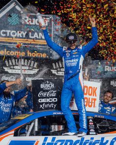 a man standing on top of a car with confetti in the air