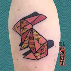 a small tattoo on the leg of a person with an origami style design