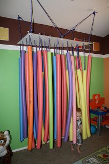 a child standing in front of a bunch of surfboards hanging from a ceiling rack