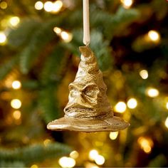 a gold bell ornament hanging from a christmas tree