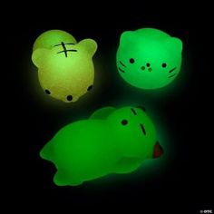 three glowing stuffed animals in the dark