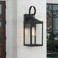 Illuminate your front door or garage with this 1-light classic new traditional Exterior lantern lighting fixture. It's rated wet locations, and its sleek frame is made from metal in a powder-coated black finish that complements your decor from classic to rustic. It features 4 clear glass panels with its square shape enclosed in a black and sleek clean-lined framework. E26 vintage bulb is recommended to fully illuminate the glass and complement the overall aesthetic. Ideal for Front Porch, Patio, Exterior Light Fixture Over Front Door, Black Farmhouse Outdoor Light Fixtures, Black Outside Lights, Outdoor Wall Lights On House Garage, Door Lights Exterior, Outside Lights Front Door, Garage Door Lights Exterior, Exterior Lights On House, Outdoor Wall Sconces Exterior Lighting