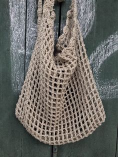 a crocheted bag hanging on a wooden door