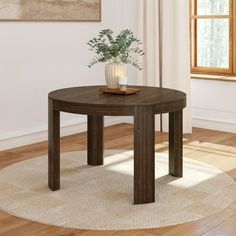 a table with a vase on top of it in front of a window and rug