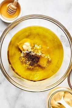 an overhead view of a bowl of soup with spoons and honey on the side