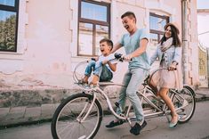 a man, woman and child are riding on a bicycle