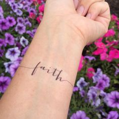 a woman's arm with the word love written on it in cursive handwriting