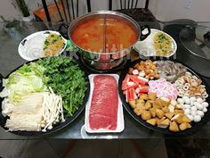 a table topped with lots of food and bowls filled with meat, veggies