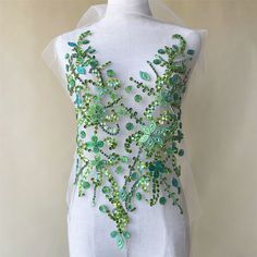 a white dress with green beads on it