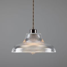 a clear glass light hanging from a ceiling fixture with a brown cord attached to it