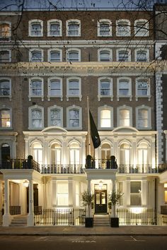 the building is lit up at night with many windows and balconies on it