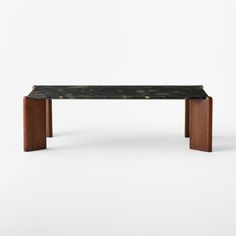 a black marble top coffee table with wooden legs and an open shelf on the side