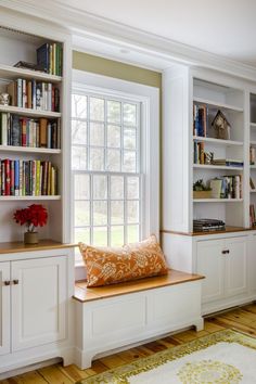 a window seat in front of a bookcase filled with books