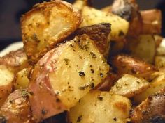 close up view of cooked potatoes with seasoning on the top and bottom, in a white bowl