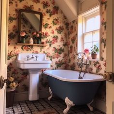 an old fashioned bathtub and sink in a bathroom with floral wallpaper on the walls