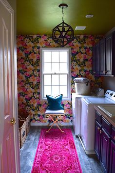 a pink rug is in front of a window with a flowered wallpaper behind it