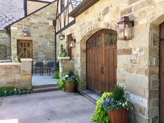 a house with two large brown doors and some flowers in front of the entrance to it