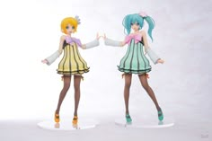 two figurines are standing next to each other in front of a white background